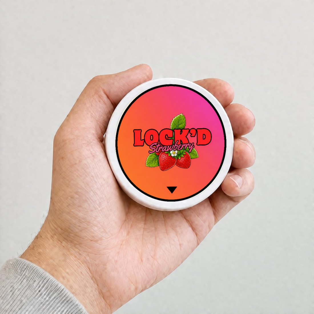 A hand holding a LOCK'D Strawberry tin